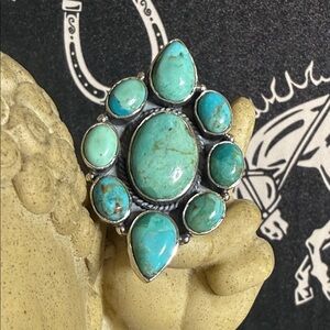 Kingman Mine  
Large center stone , 8 surrounding stones
Adjustable 
Sterling